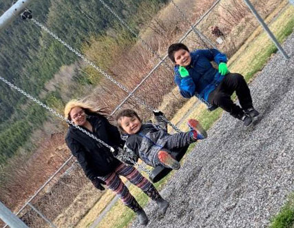 FNHA-Laxgaltsap-kids-on-swings-with-parent.JPG